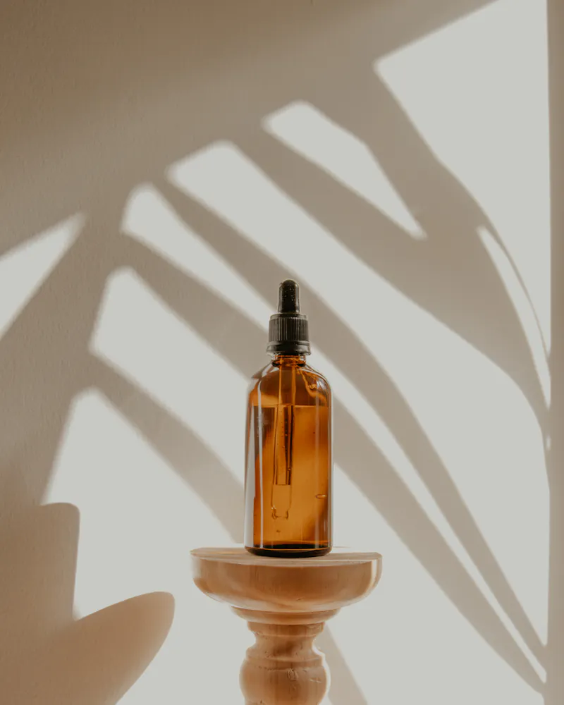 Frasco de óleo essencial iluminado por luz natural